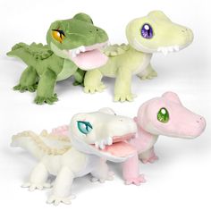 three small stuffed alligators are shown in different colors and sizes, one is pink, the other is green