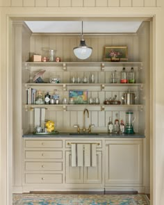 a kitchen with white cabinets and shelves filled with various items on top of each shelf