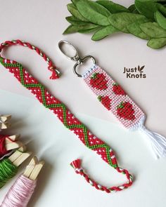 a red and green beaded keychain next to other items on a table