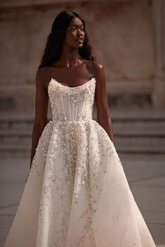 a model walks down the runway in a strapless wedding dress