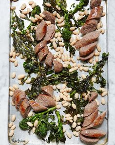 some food is laying out on a tray with broccoli and beans in it