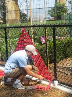 a man is working on the side of a fence