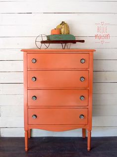 an orange dresser with some pumpkins on top