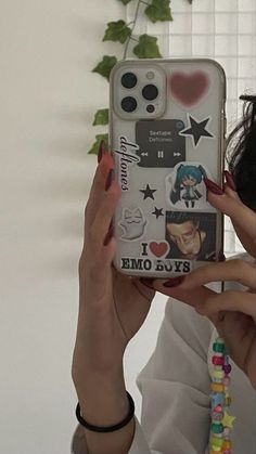 a woman holding up a cell phone case with stickers on the back and sides