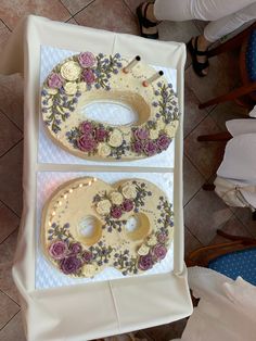 two decorated trays sitting on top of a table next to each other with buttons and flowers