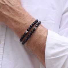 This stretch to fit men's black onyx bracelet offers a subtle blend of bold design & sophistication. Adorned with 6mm semi precious Black Onyx gemstones & Sterling silver focal bead. Features: Powerful Properties: Black onyx is celebrated for its ability to shield the wearer from negative energy and foster emotional strength, making it much more than a fashion statement. Perfect Fit: Stretch to Fit, available in four wrist sizes - 7, 7.5, 8, and 8.5 inches, ensuring a comfortable fit for all. Cu Black Bracelets For Men, Silver Onyx Beaded Bracelets With 8mm Beads, Mens Black Bead Bracelet, Men’s Stretch Bracelet, Masculine Adjustable Black Bracelets, Men’s Freshwater Black Pearl Bracelet, Emotional Strength, Black Onyx Bracelet, Onyx Bracelet