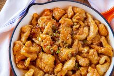 a white bowl filled with chicken on top of a table