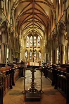 the inside of a church with pews and stained glass windows