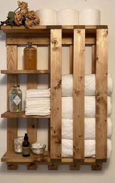 a wooden shelf filled with lots of white towels and toilet paper on top of it