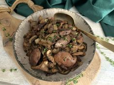 a bowl filled with mushrooms on top of a wooden cutting board