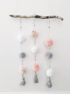 a wall hanging with pom poms and beads