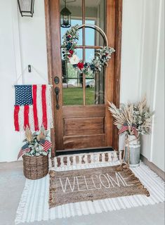 an american flag wreath is on the front door of a house with welcome home sign