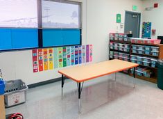 an empty classroom with several tables and bins