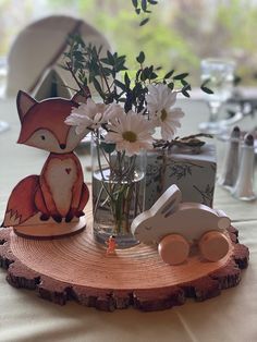 a vase filled with white flowers sitting on top of a wooden table next to a toy car