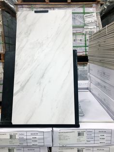 white marble tiles are stacked on top of each other in a store display case for sale