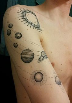 a man with tattoos on his arm that has planets and sun in the sky above it