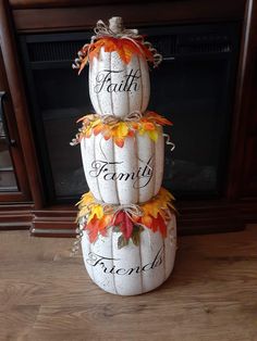 three white pumpkins stacked on top of each other with the words faith, family and friends painted on them