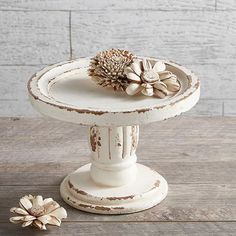 a white cake stand with flowers on top