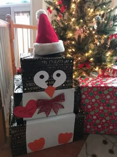 a stack of presents with a christmas tree in the background