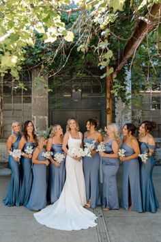 a group of women standing next to each other in front of a tree with flowers