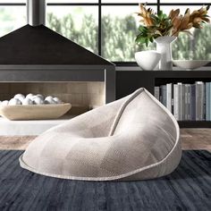 a large bean bag chair sitting on top of a rug in front of a fireplace