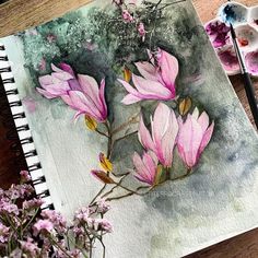 a watercolor painting of pink flowers on a table next to some paintbrushes