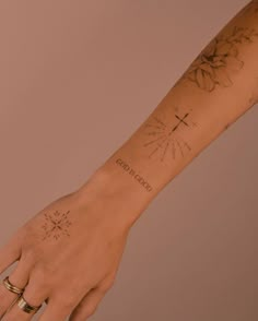 a woman's arm with tattoos on it and her hand holding the wrist tattoo