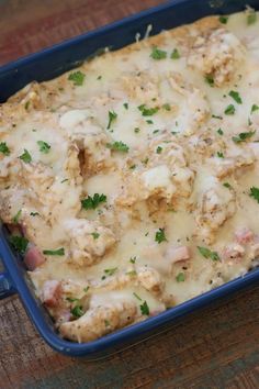 a casserole dish with meat, cheese and parsley in it on a wooden table