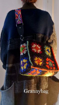 the back of a woman's purse with multicolored crocheted flowers on it