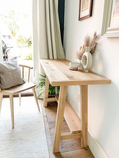 a wooden table sitting on top of a hard wood floor next to a white rug