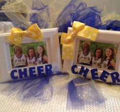 two frames decorated with blue and yellow ribbons are sitting next to each other on a table