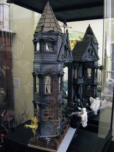 a display case with two model houses on it's sides and one in the middle