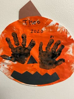 a paper plate with handprints on it in the shape of a jack - o'- lantern