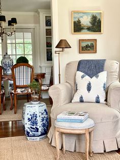 a living room with blue and white decor on the walls, furniture and pictures above