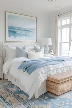 a large bed sitting in a bedroom on top of a blue and white rug next to a window