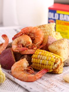 corn on the cob, potatoes, and shrimp are sitting next to each other