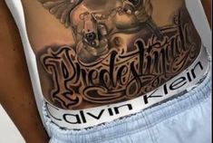 a man's stomach with an eagle tattoo on it and words written in cursive writing