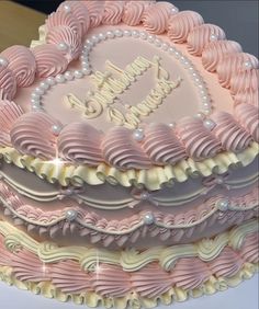 a pink and white heart shaped cake sitting on top of a table