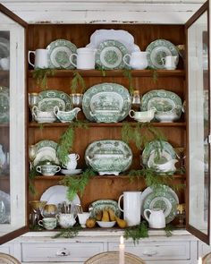 a china cabinet filled with green and white dishes