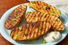 some grilled food is on a plate with onions and green onion garnish