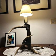 a lamp that is on top of a table with a deer's antler