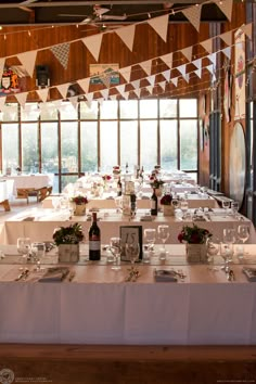 a long table is set with wine glasses and place settings