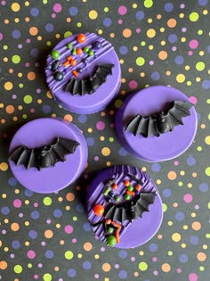 three purple buttons with bats and candy on them