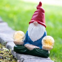 a gnome figurine sitting on top of a stone wall