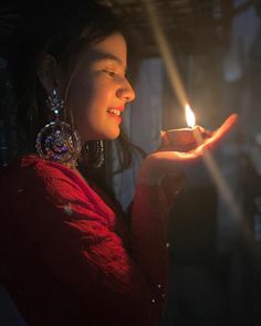 a woman holding a lit candle in her hand