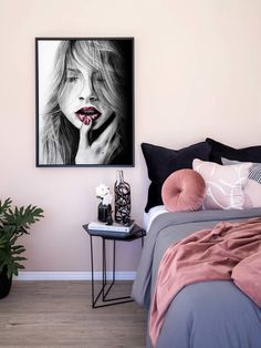 a black and white photo of a woman's face on a wall above a bed