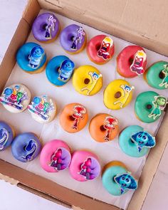 an open box filled with lots of different colored doughnuts on top of each other