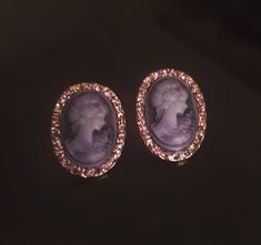 Gorgeous soft purple cameo. Stone or lava carved but can not tell for sure. I have ruled out shell, porcelain and plastic through simple at home tests. Looking at the back of the earrings you can see the black stone or lava. No light passes through the cameo from the front to the back. One of the earrings is missing 2 purple stones from the perimeter, please see picture.  I have reflected the missing stones into the price. To the unknowing eye or normal glance, you would not be able to tell anything is missing because of the overall glimmer of the other stones. The details on these are stunning and in great shape. I especially love the flower shoulder detail with the bunch of leaves, very Greco-Romanesque. Face is right facing and both face the same direction. No Light, Soft Purple, Wedding Jewelry Earrings, Purple Stones, The Missing, Black Stone, Wedding Earrings, Wedding Jewelry, Violet