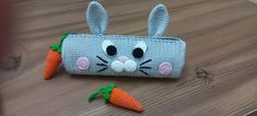 a crocheted bunny wallet with two carrots