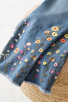 a straw hat and blue jean skirt with flowers on it